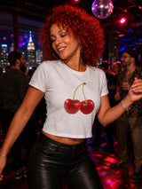 Woman wearing a white t-shirt with red cherries in a nightclub setting