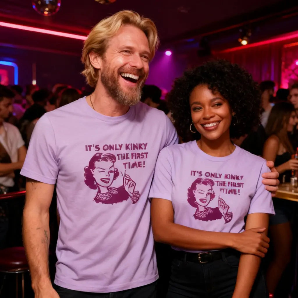 Two people wearing matching purple t-shirts with a graphic and text in a nightclub setting.