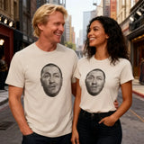 Two people wearing t-shirts with printed faces on a city street.